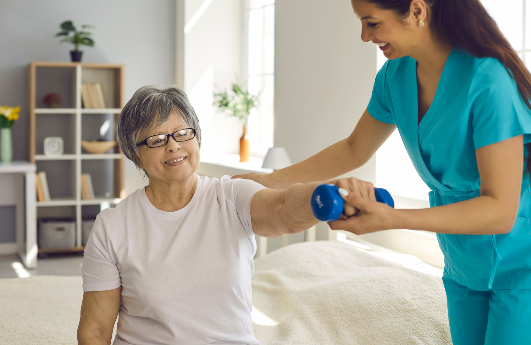 mobile physiotherapy of old Asian women with glasses assisted by a women physiotherapist